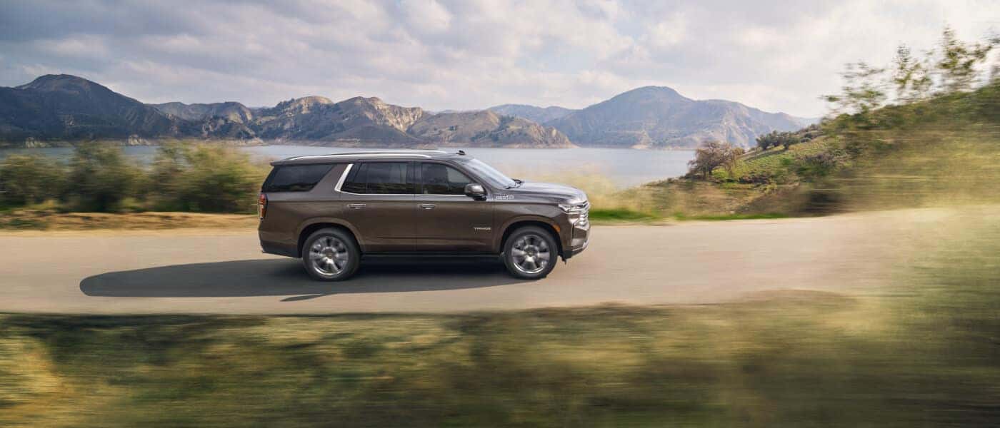 2021 Chevy Tahoe driving on a road by a lake side exterior view