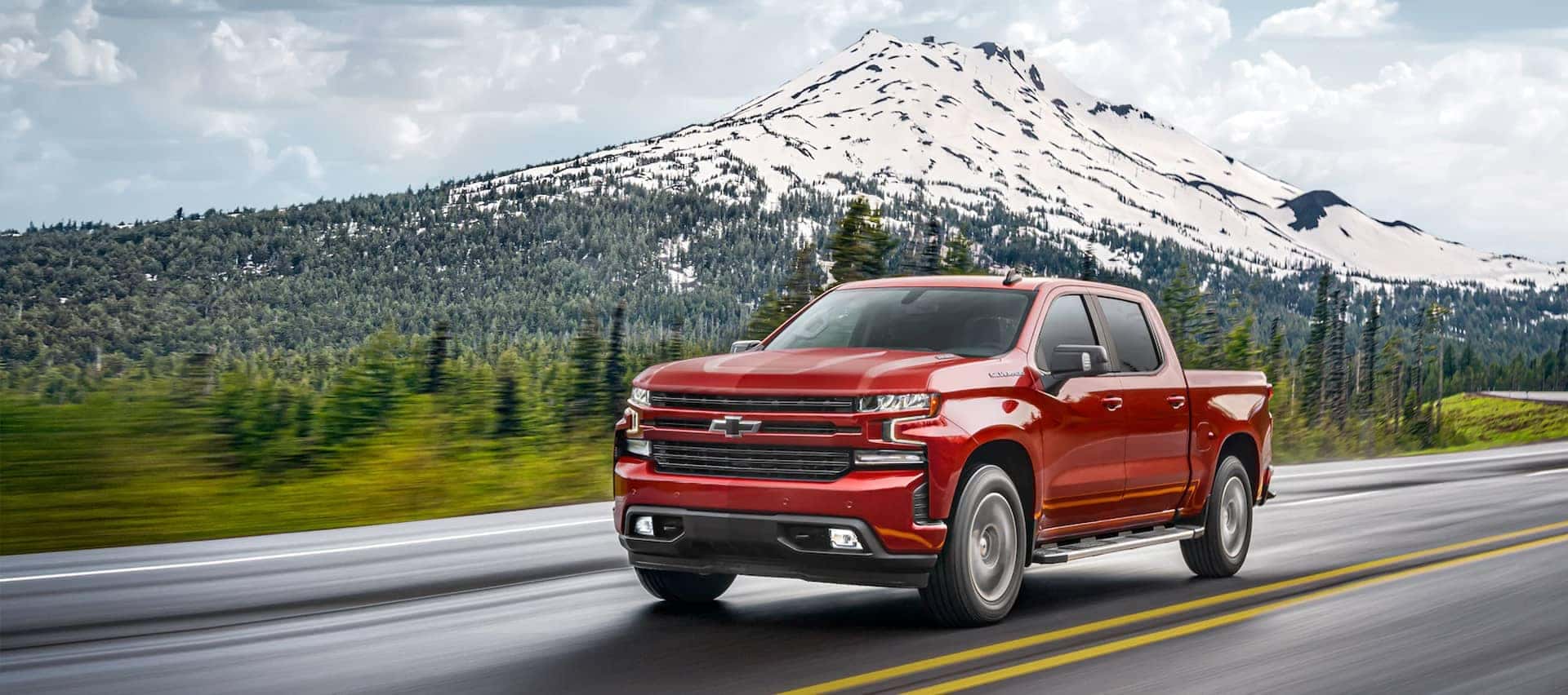 Red chevy Truck with snowy mountains in the back