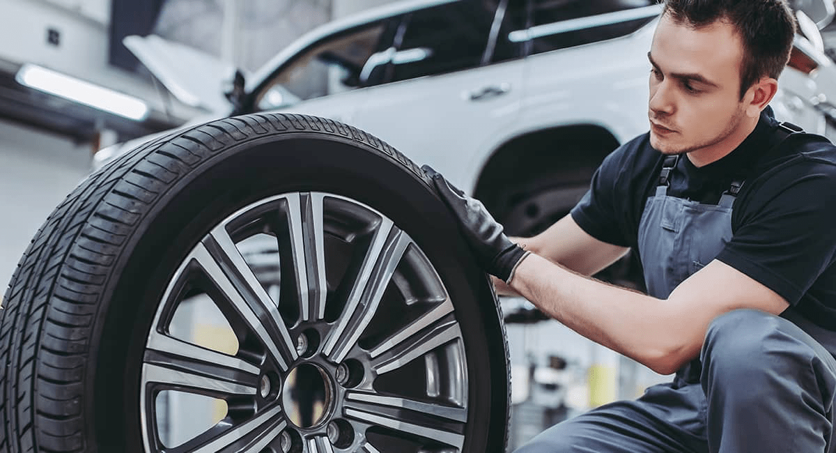 technician examines car tire