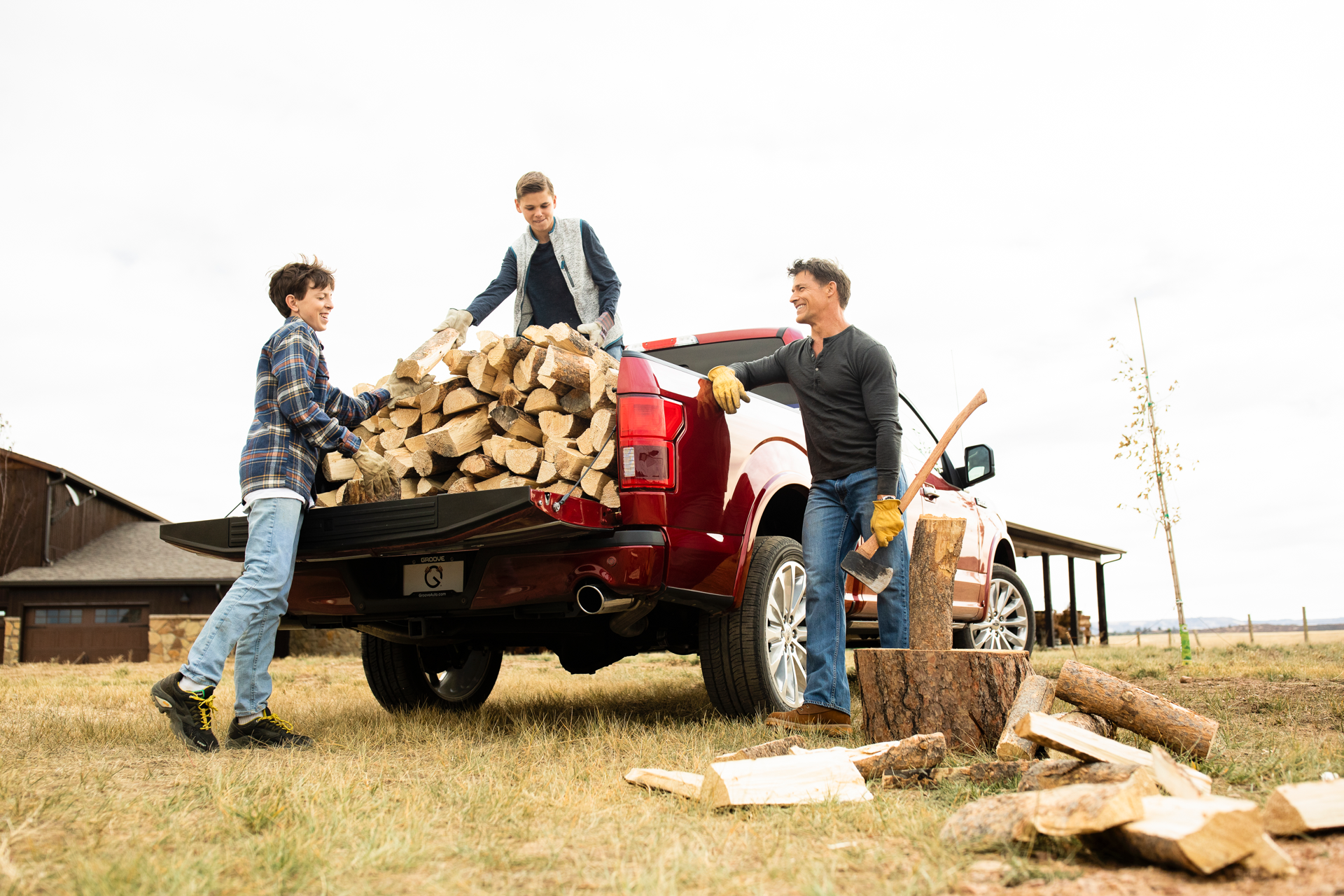 man and boys unload lumber from Groove Ford truck
