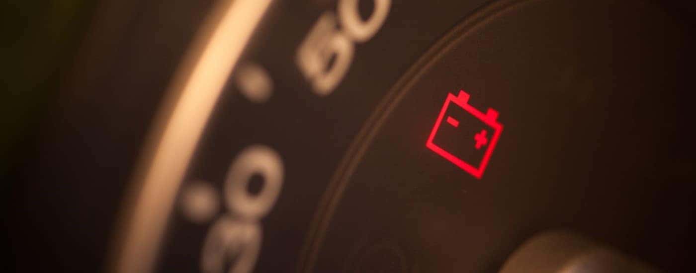 A battery light is shown on an instrument cluster.