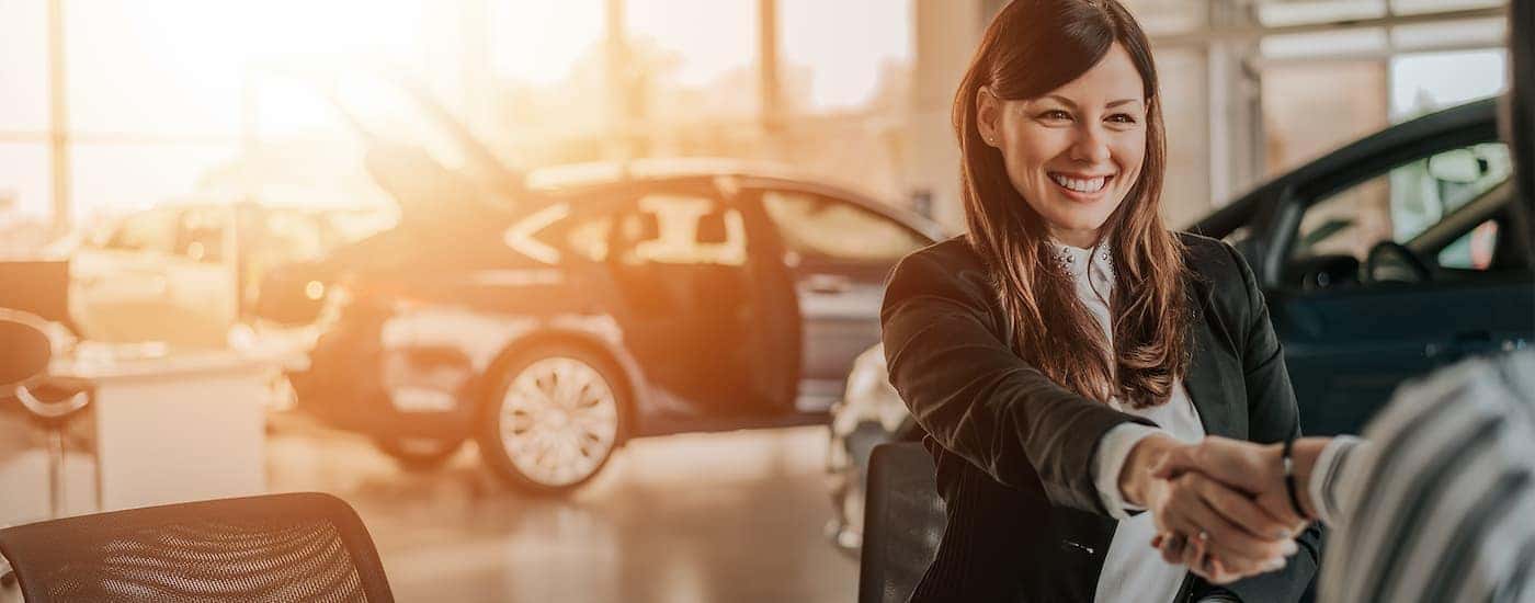 A person is shown sitting in a Midlothian Toyota dealership shaking hands with a sales person.