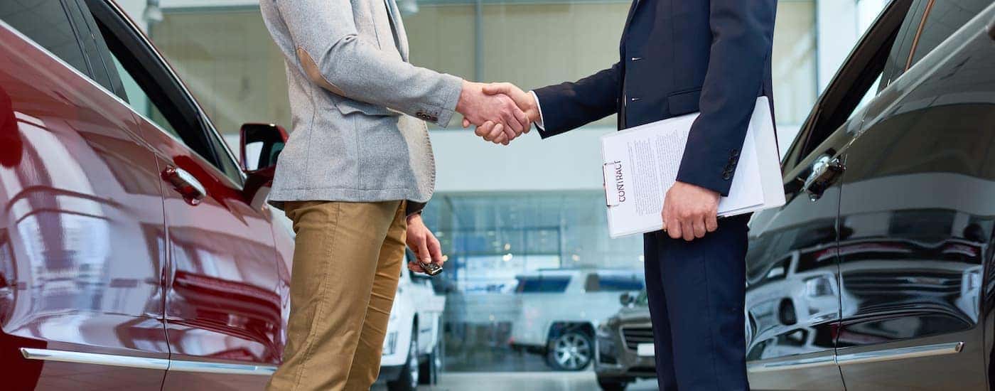 Two people are shown shaking hands at a Midlothian Toyota dealership.