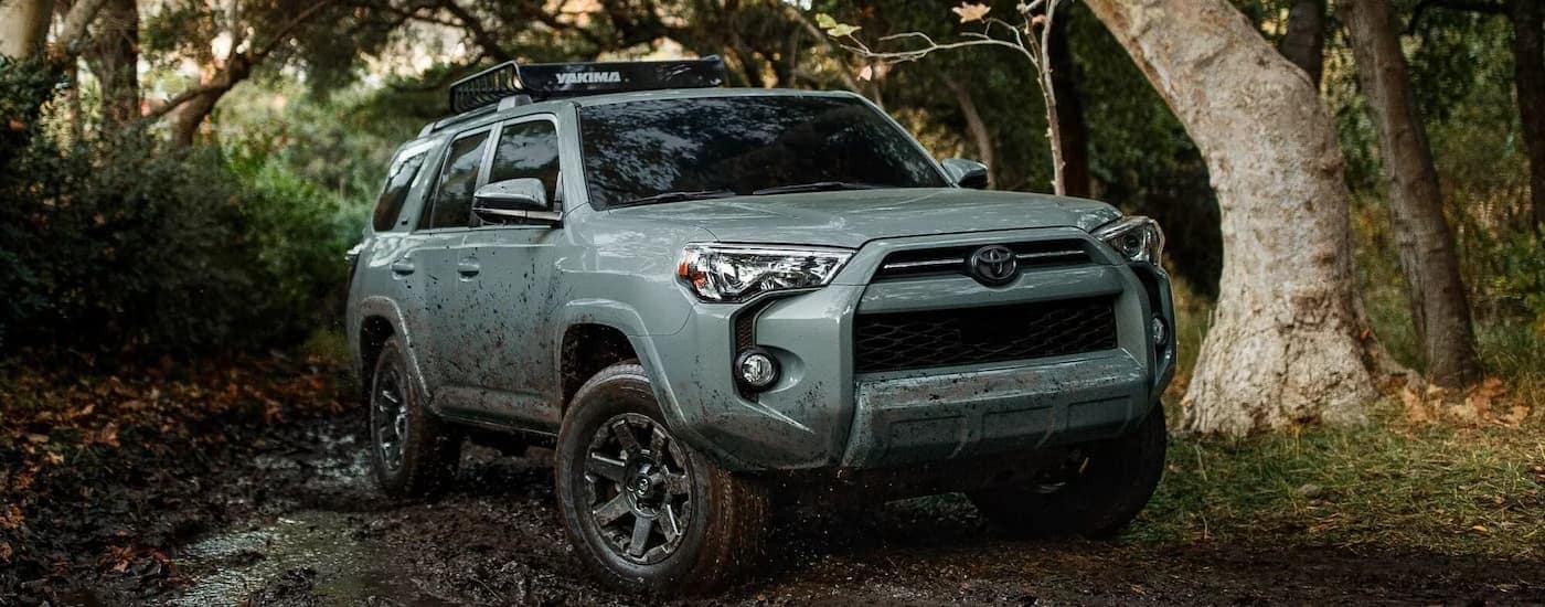 A blue 2022 Toyota 4Runner Trail Edition is shown off-roading on a muddy path.