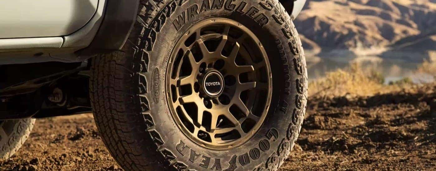 A close up shows the bronze wheel on a green 2023 Toyota Tacoma, one of the most popular Toyota trucks for sale.