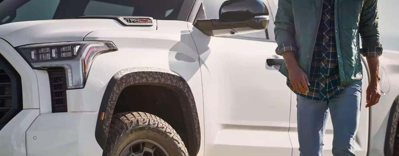 A person is shown walking near a white 2023 Toyota Tundra TRD Pro.