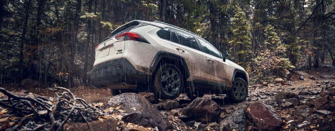 A white 2022 Toyota RAV4 TRD is shown on a rainy trail after leaving a Tuckahoe used Toyota dealer.