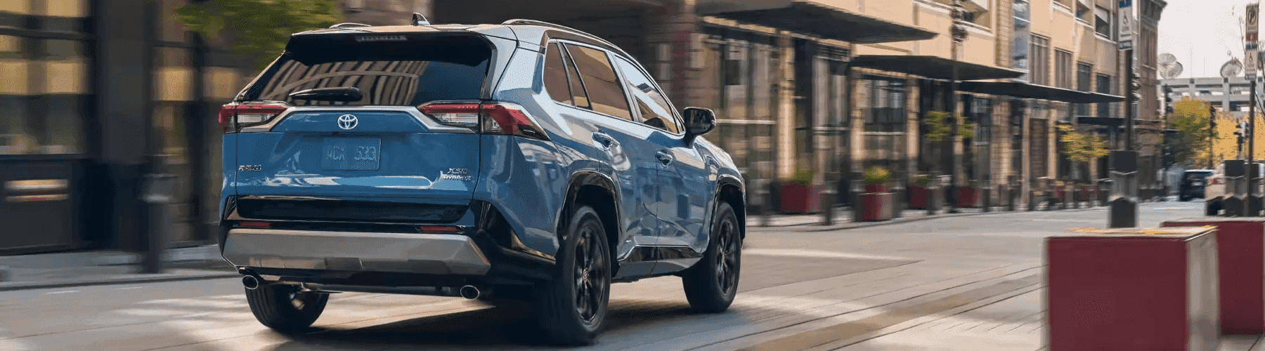 Blue-RAV4 drives-city-street-fast