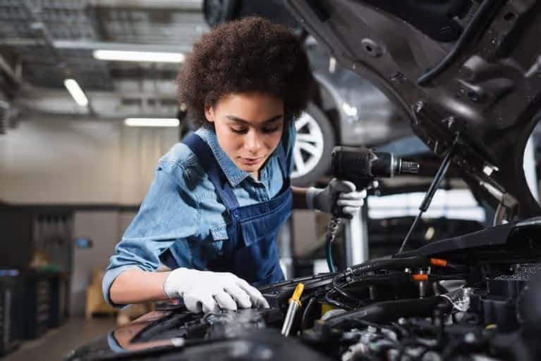A mechanic looking into a hood