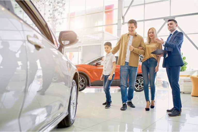 family-looking-at-a-new-vehicle-mobile