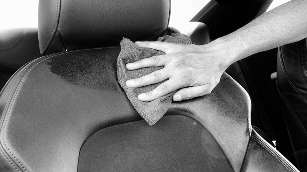 a lone hand rubbing a seat with a cloth