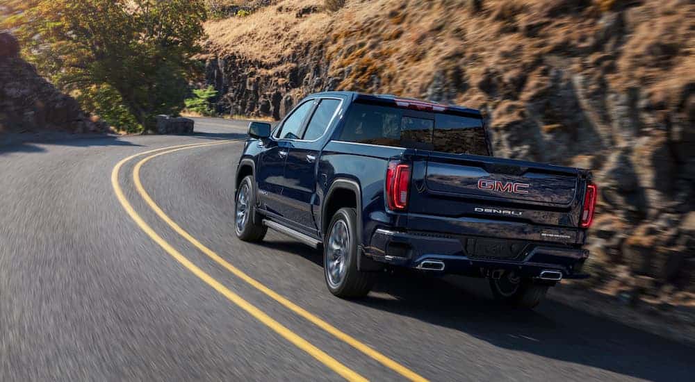 a blue 2025 GMC Sierra 1500 Denali from the rear at an angle.
