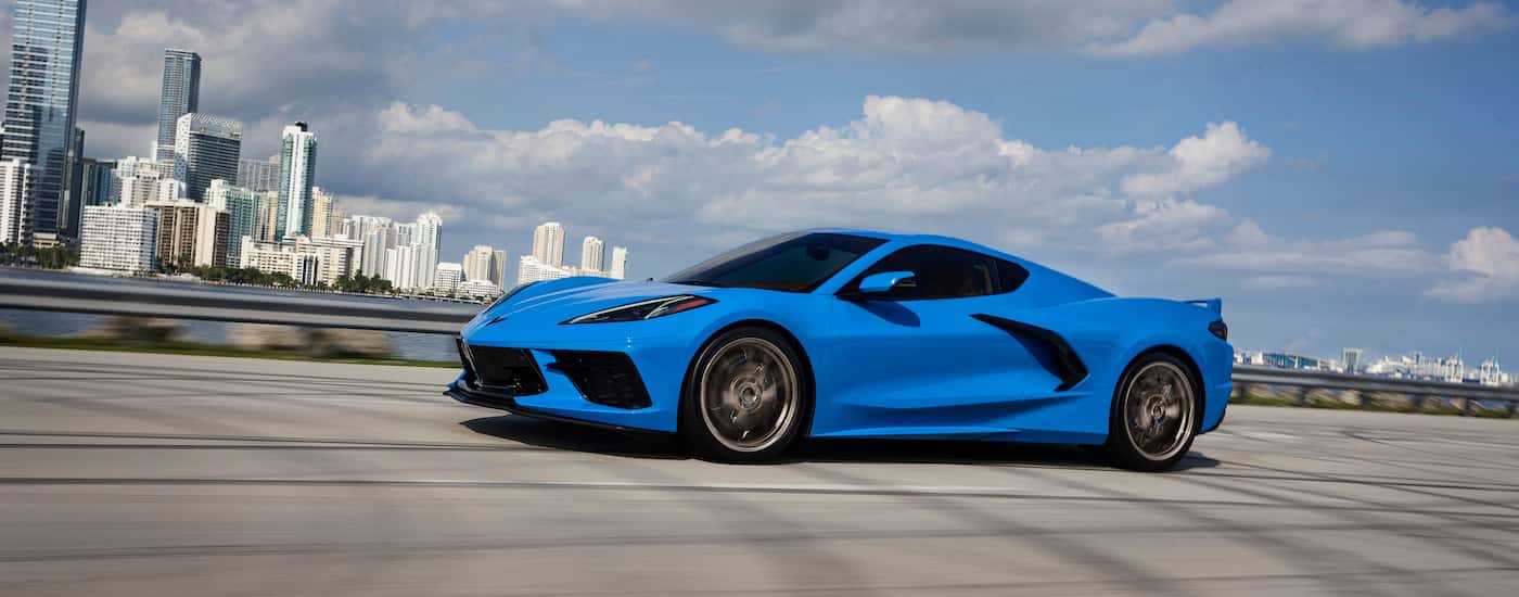 A blue 2025 Chevy Corvette from the side after leaving a Chevy dealer.