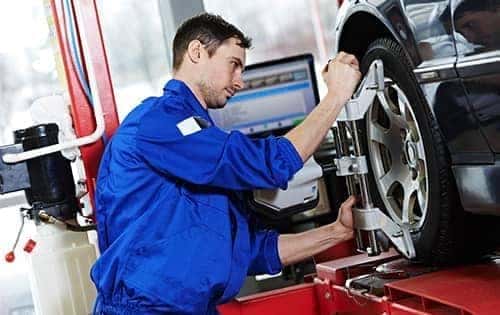 technician measuring tire alignment