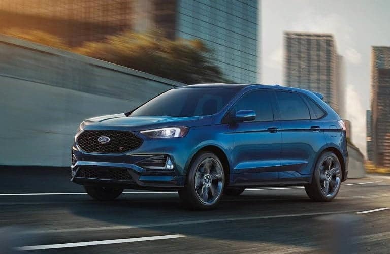 2019 Ford Edge blue driving down a city road at speed