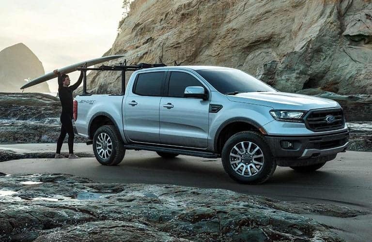 2019 Ford Ranger white side view being loaded with a surfboard