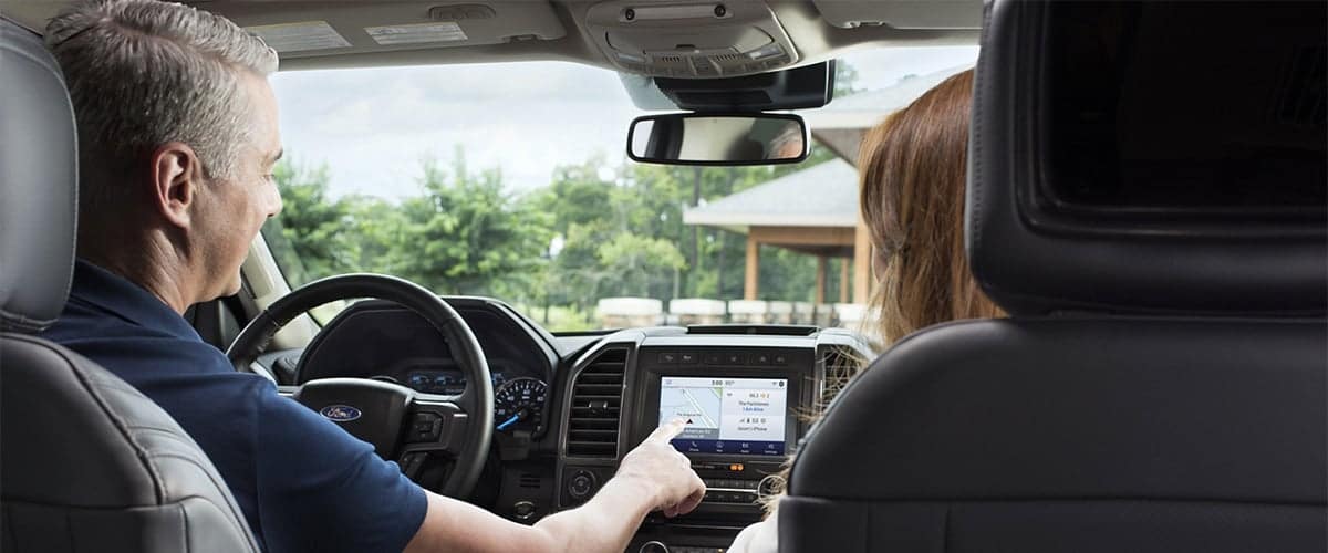 Couple driving Ford Expedition with Navigation