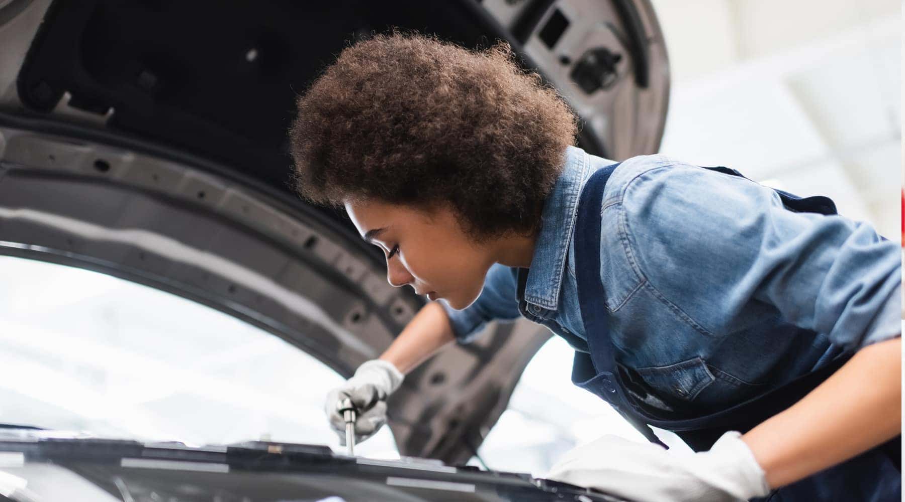 female technician repairing car engine