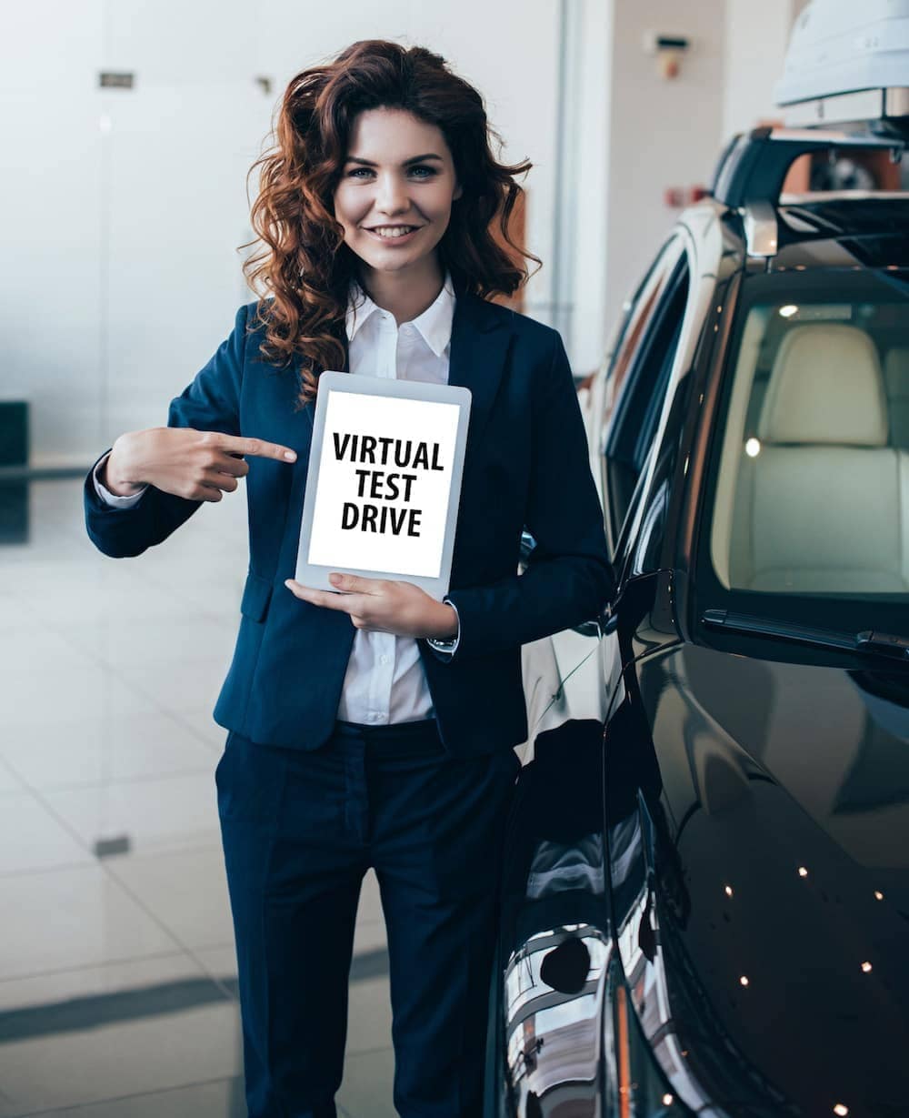 A woman holding a virtual test drive sign