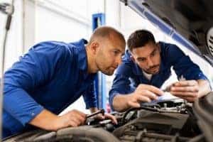 Mechanics Looking at Car