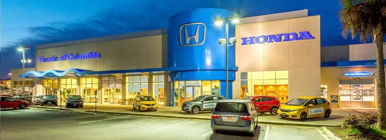 An exterior shot of a Honda dealership at night.