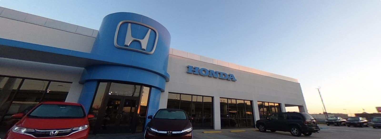 An exterior shot of a Honda dealership in the day.