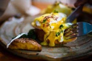 Eggs Benedict being Cut with Knife