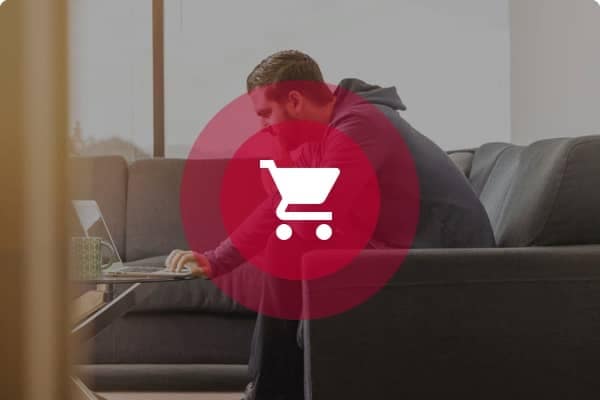person sitting on a couch with a shopping cart icon