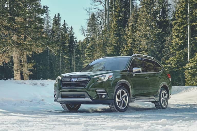 2022 Subaru Forester parked by a snowbank in a forest_mobile