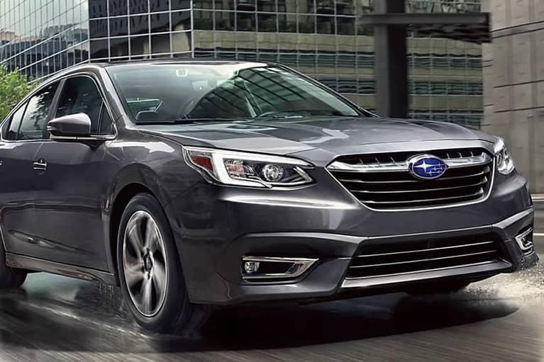 2022 Subaru Legacy-front 3qview-driving by glass skyscrapers-grey_mobile