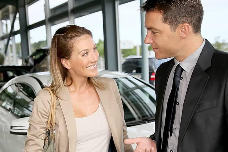 Car salesman discussing a car purchase with a female customer