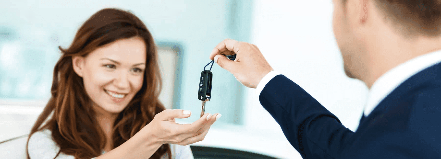 happy-woman-receives-car-keys-from-car-dealer