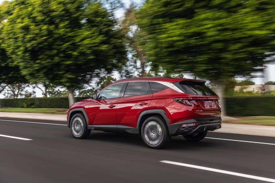 2022 Red Tucson side view driving on open road