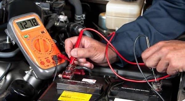 auto mechanic working on a car battery