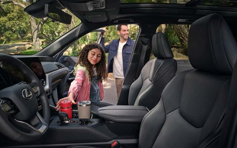 Child reaching for water bottle in a center console of a Lexus