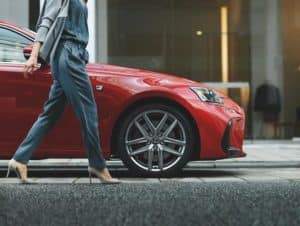 Woman walking next to her red BMW