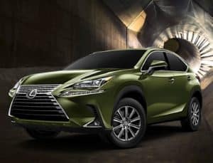 A pale forest green 2021 Lexus NX driving with its headlights on in the dark.