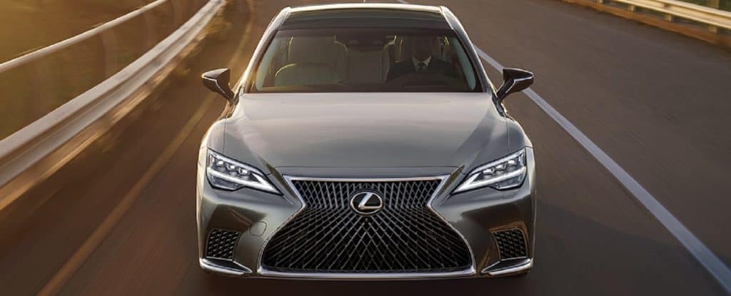 A straight on shot of the front of a grey 2021 Lexus LS as it speeds down the highway near our Lexus Dealer near Amherst NH.