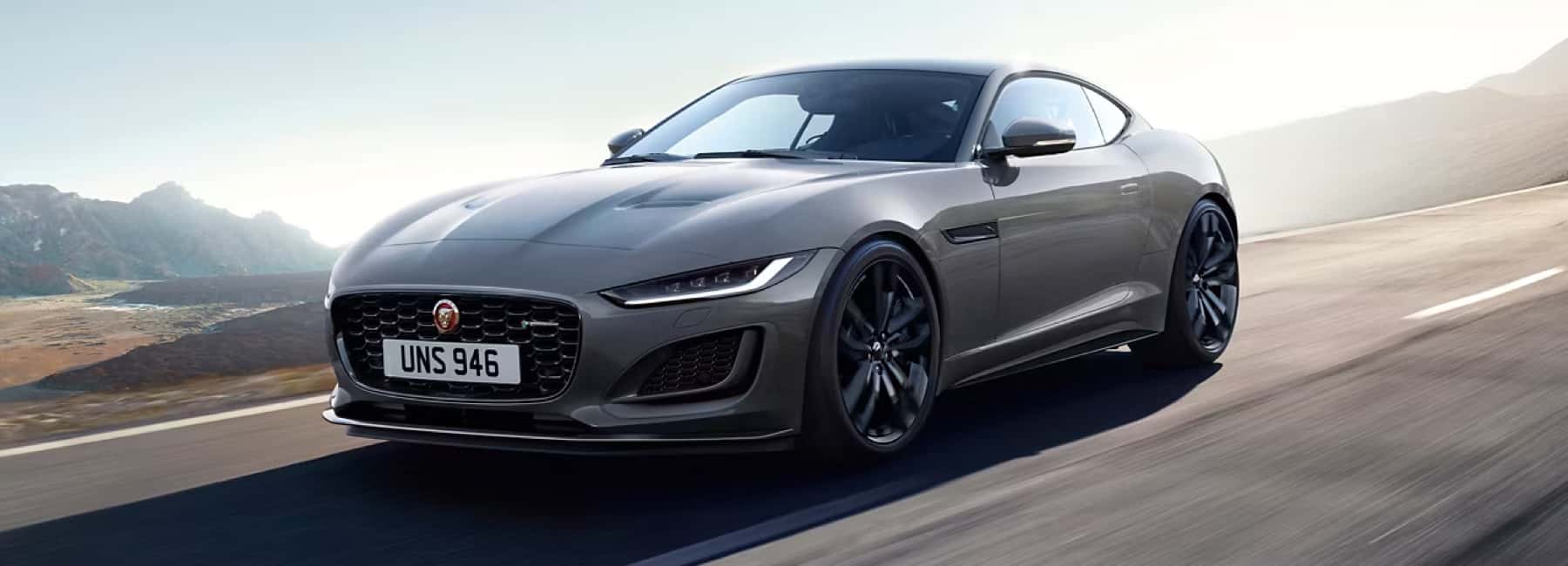 jaguar-drives-road-mountains-in-distance-desktop