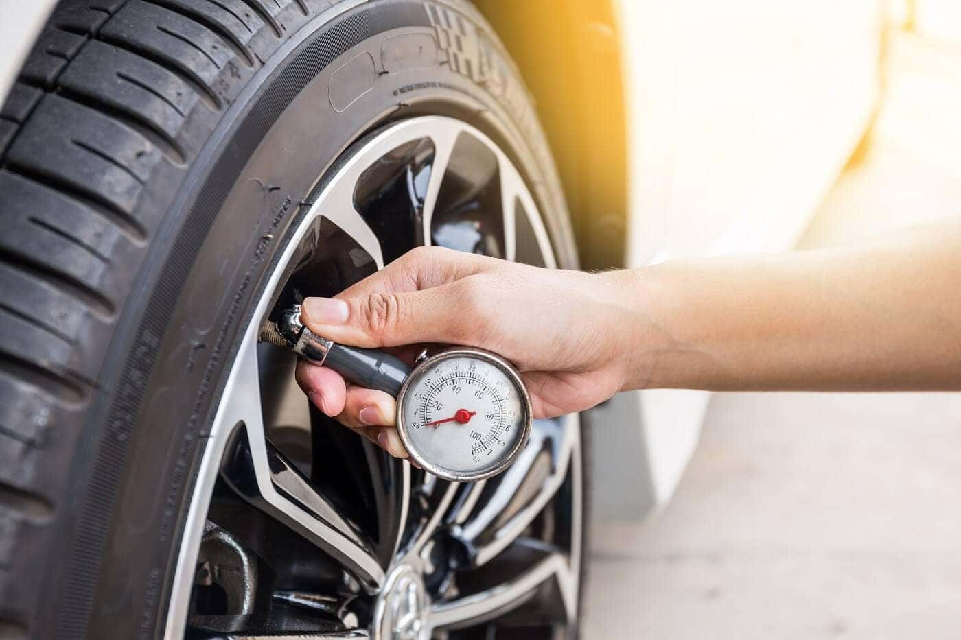 Checking tire pressure with gauge