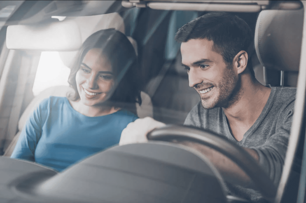 Smiling Couple test driving a car