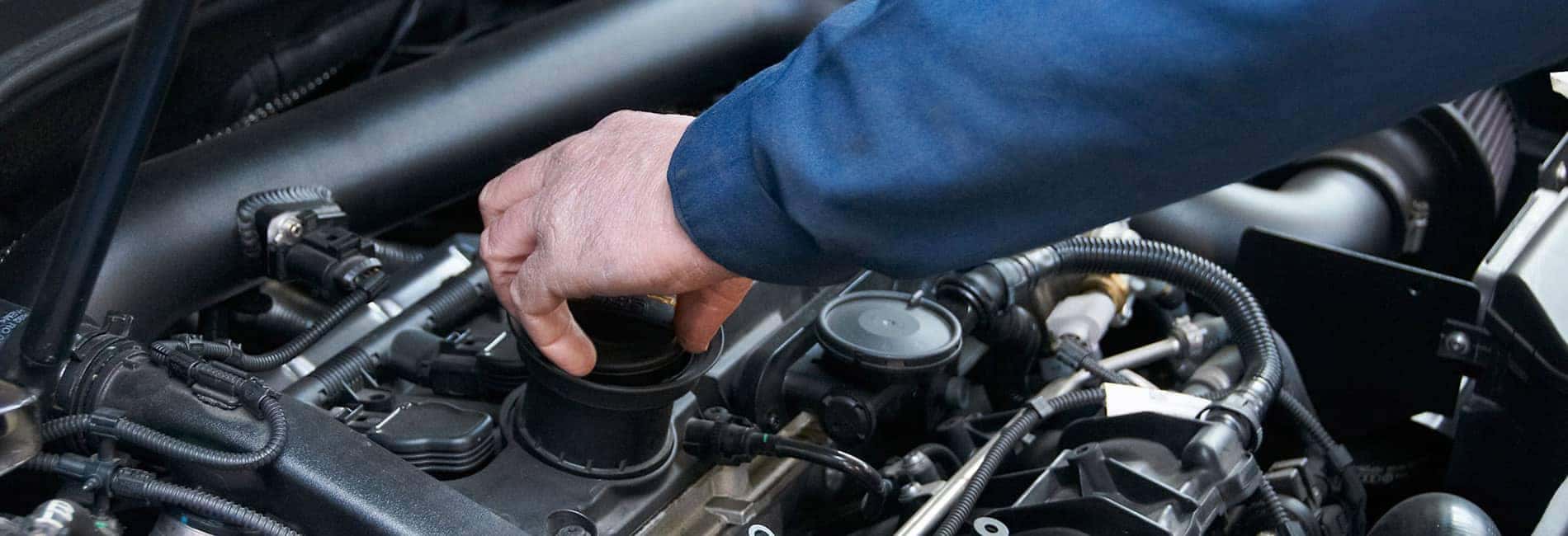 Mechanic Hand Screwing Cap on in Engine