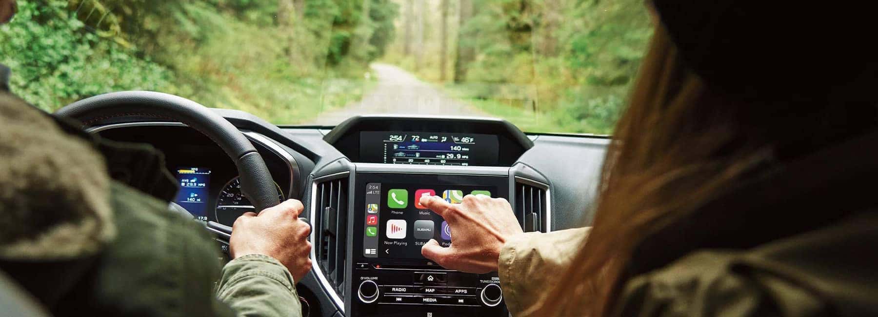 2022 Subaru Crosstrek interior driving through forest and passenger pushing buttons on console