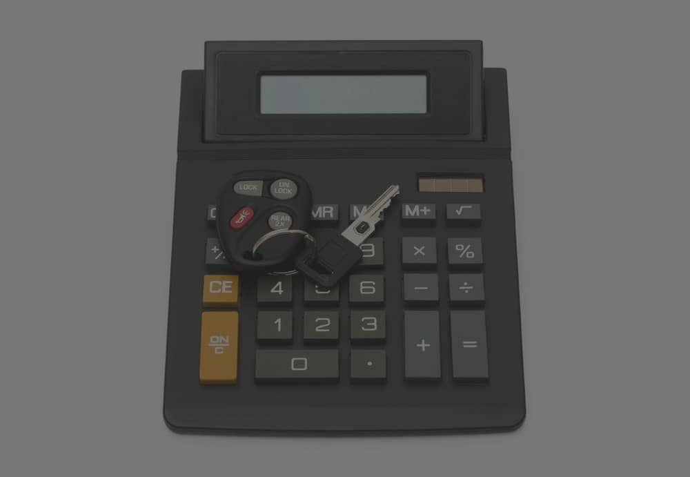 Car keys on top of a calculator
