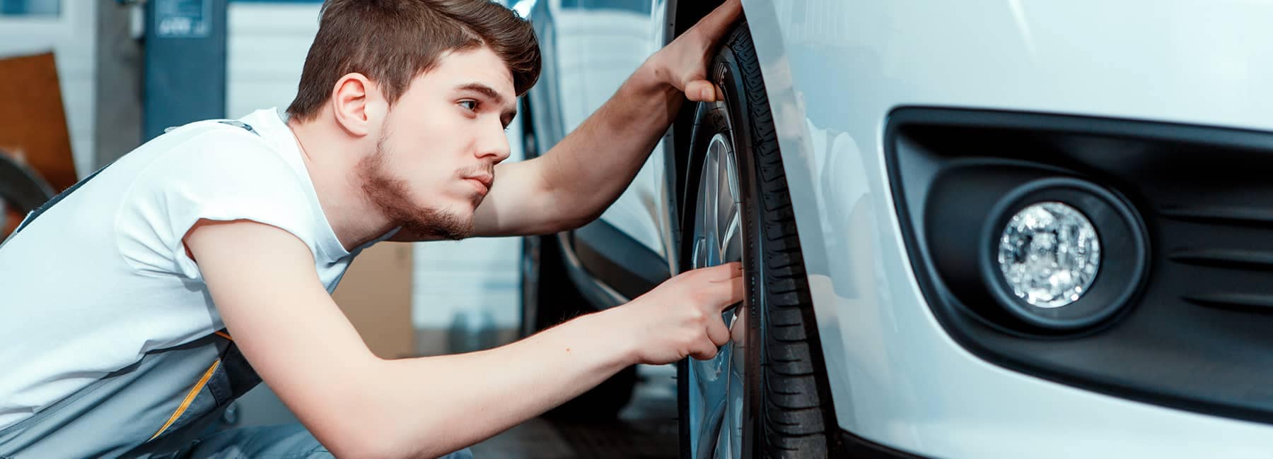 technician examines car tires
