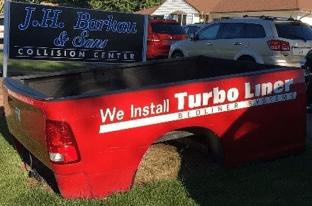 red-turbo-liner-next-to-collision-center-sign
