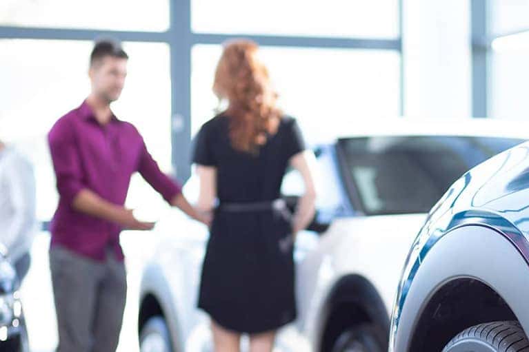 Customer looking at new cars in showroom
