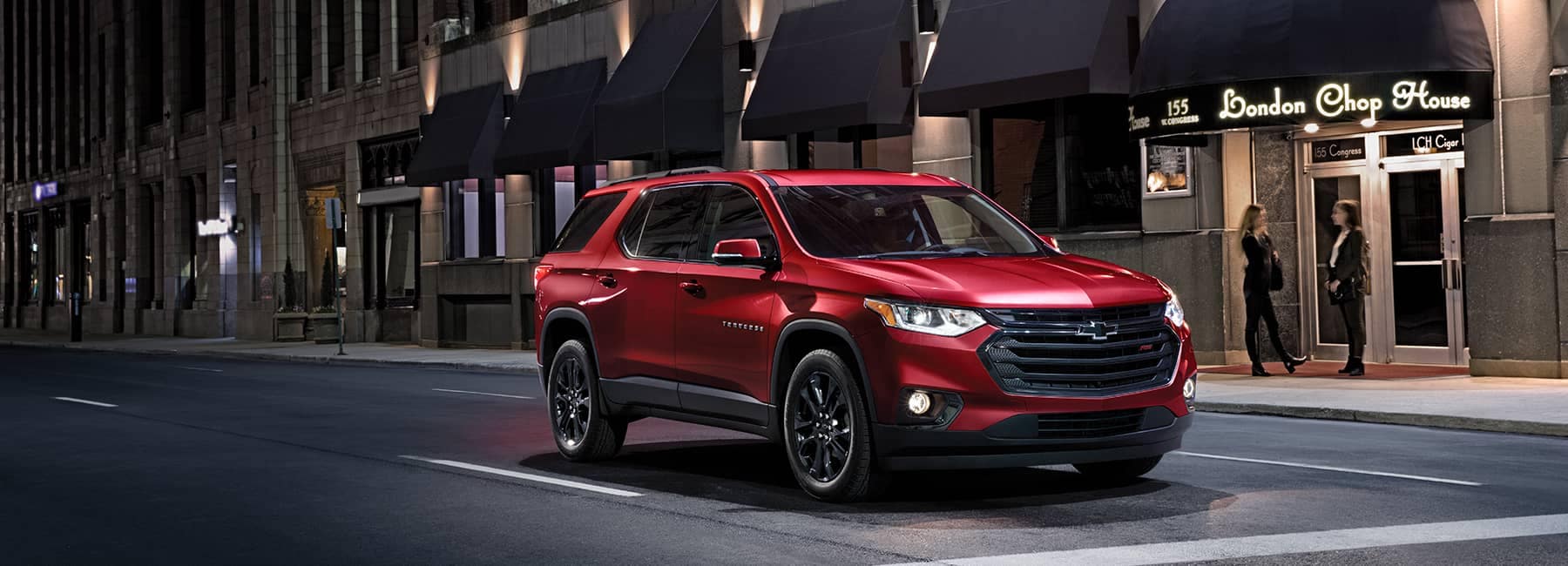 Red 2020 Chevrolet Traverse on a City St at Night