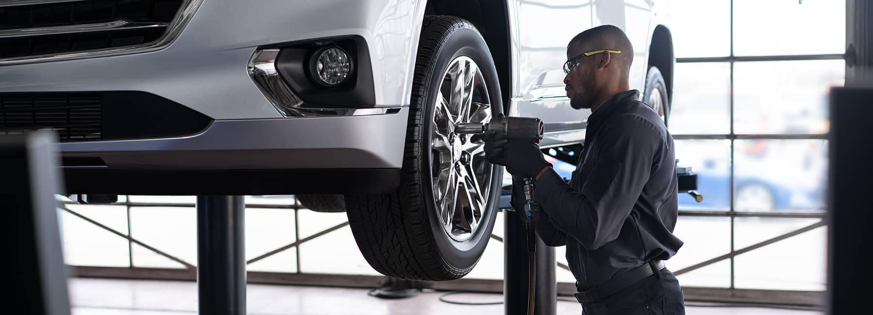 GM service technician working on car tires