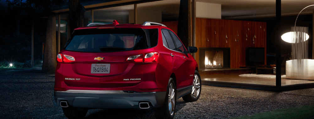 A 2020 Chevy Equinox parked outside of a new home